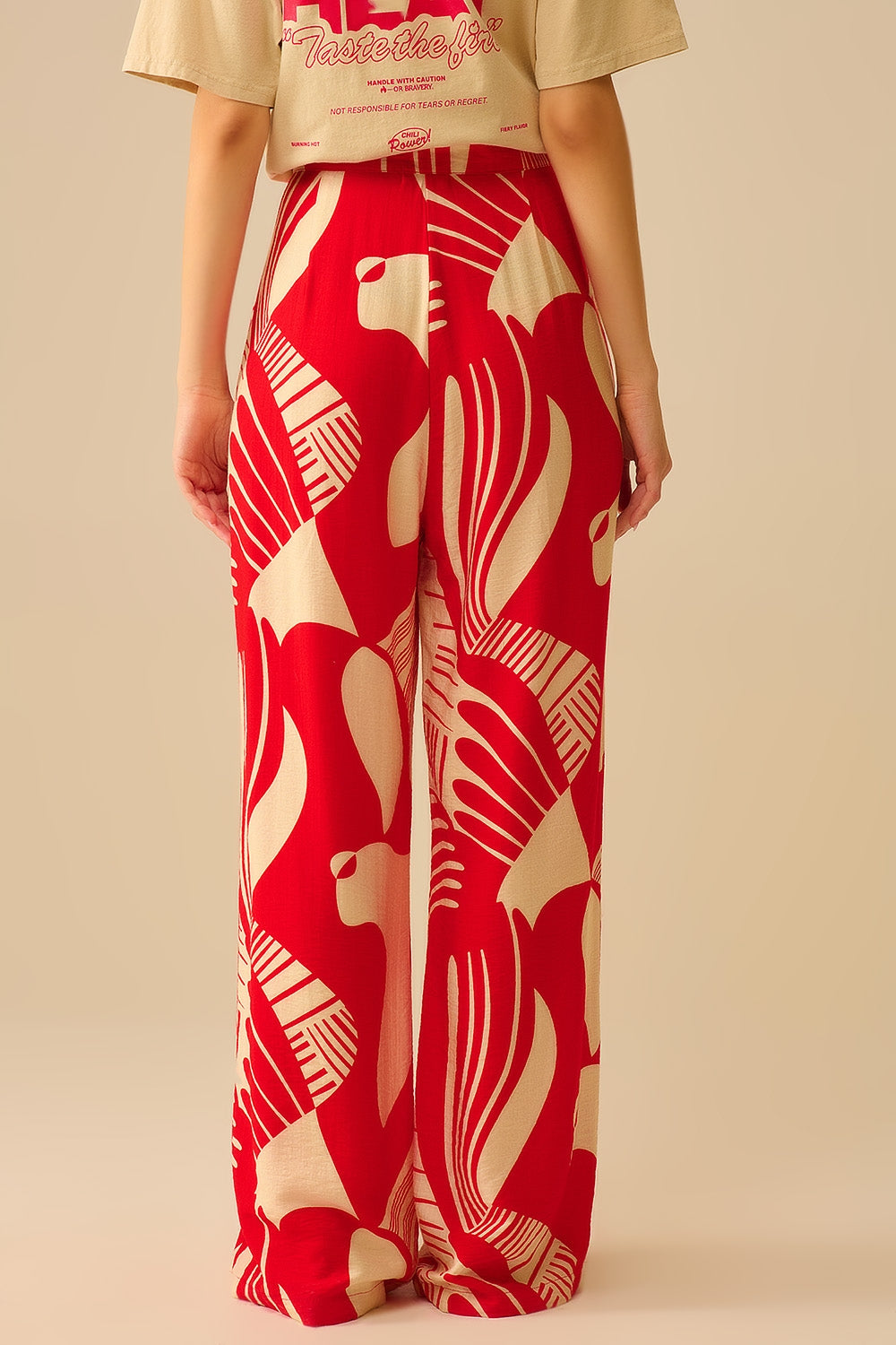 pantalón de pernera ancha con estampado abstracto en rojo y beige