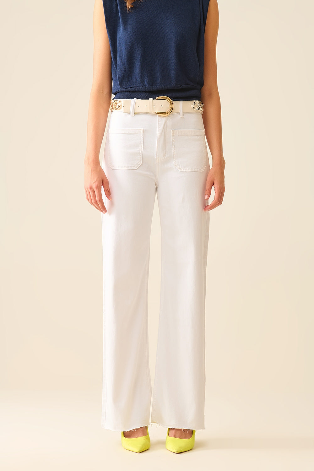 Modelo con pantalón de pernera ancha y talle alto en color crudo, combinado con un top azul.