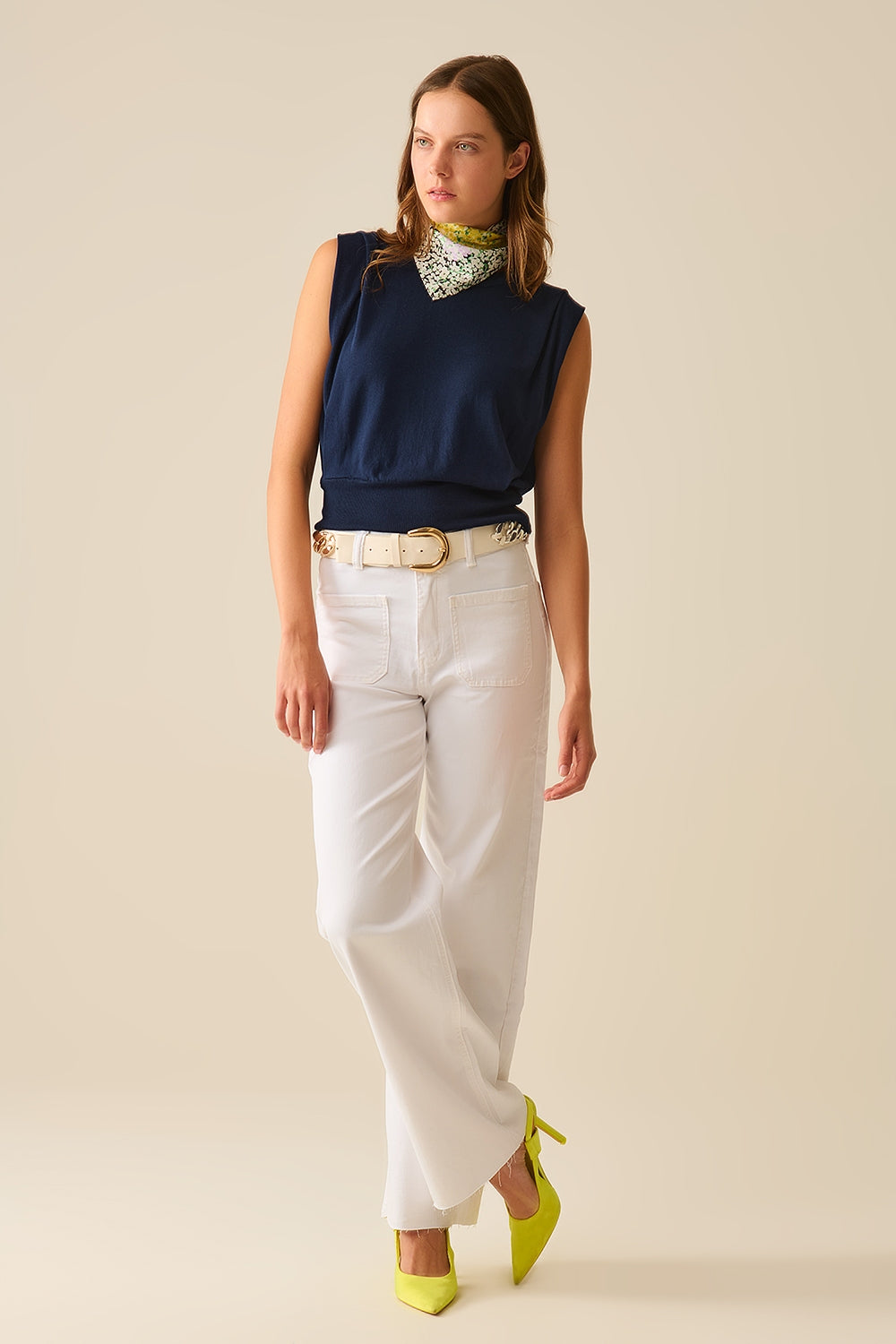 Modelo con pantalón de pernera ancha y talle alto en color crudo, combinado con un top azul.