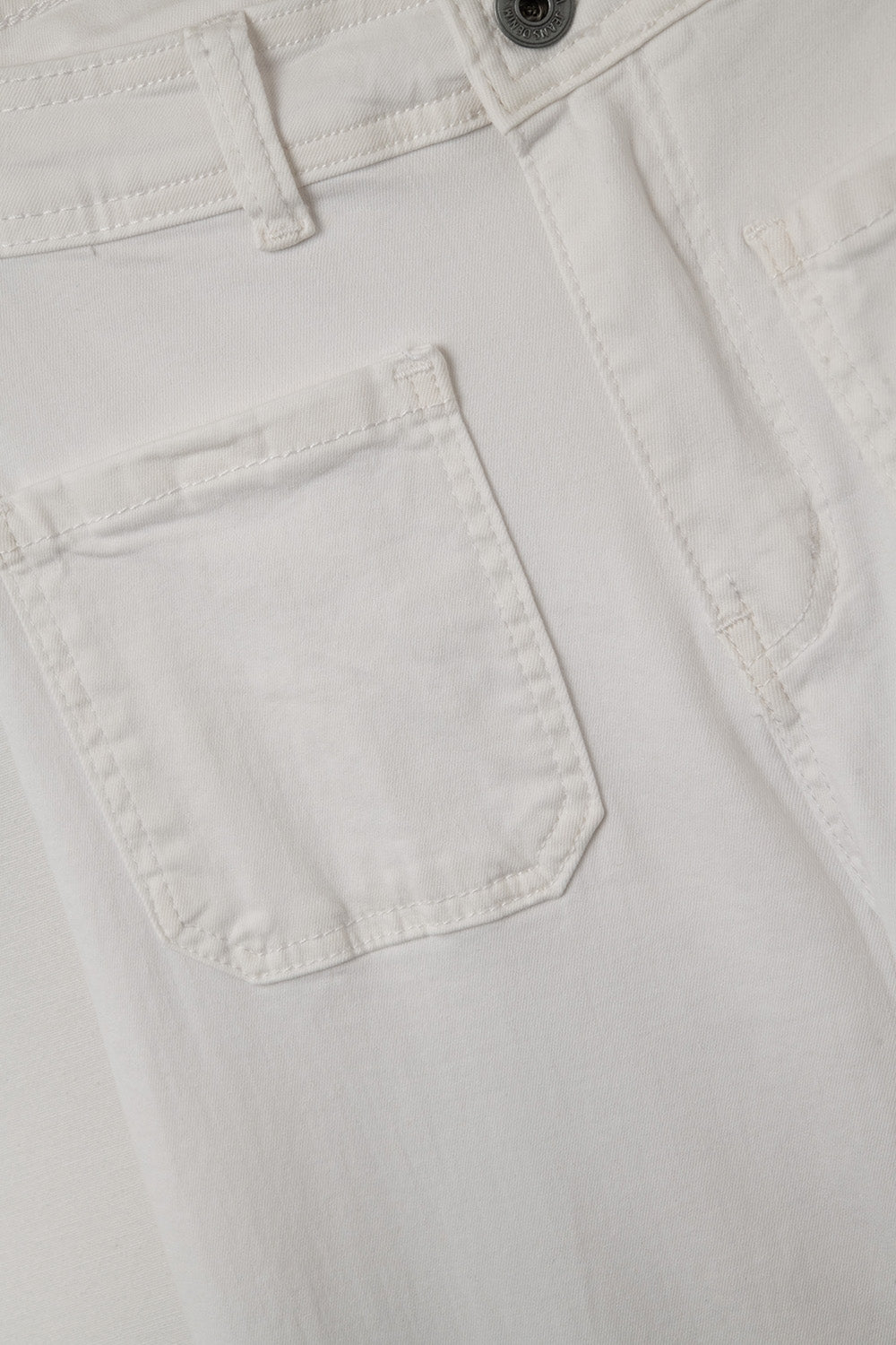 Detalle bolsillo de un pantalón de algodón en color crudo.