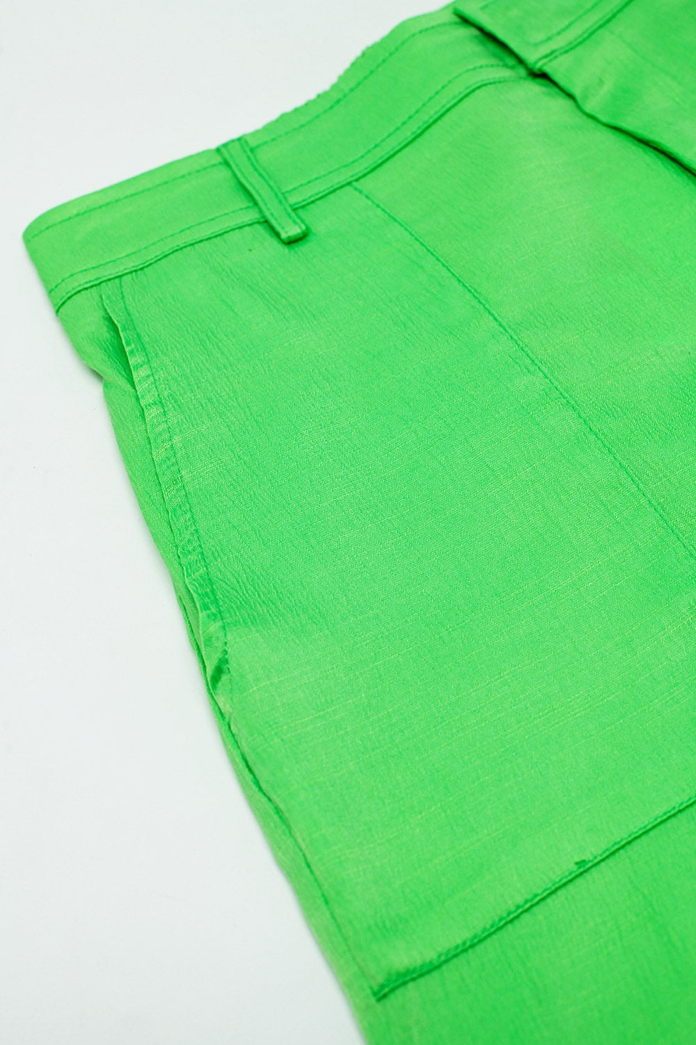 Pantalones verdes de raso con bolsillos laterales y aros para el cinturón