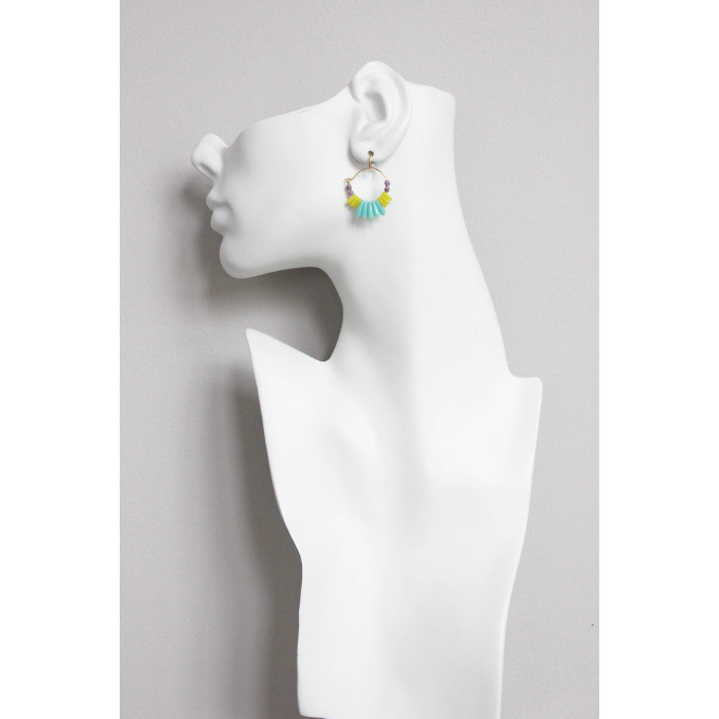 Mujer (maniquí) luciendo pendientes de aro David Aubrey de 2,8 cm. Joyas coloridas con baño de oro de 18k ideales para diario