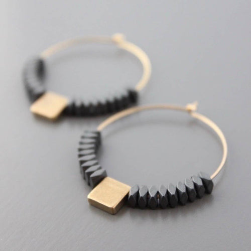 Pendientes de aro con piedras de hematita natural y cubo de latón dorado de David Aubrey, hechos a mano, exclusivos en Ivoluxt.