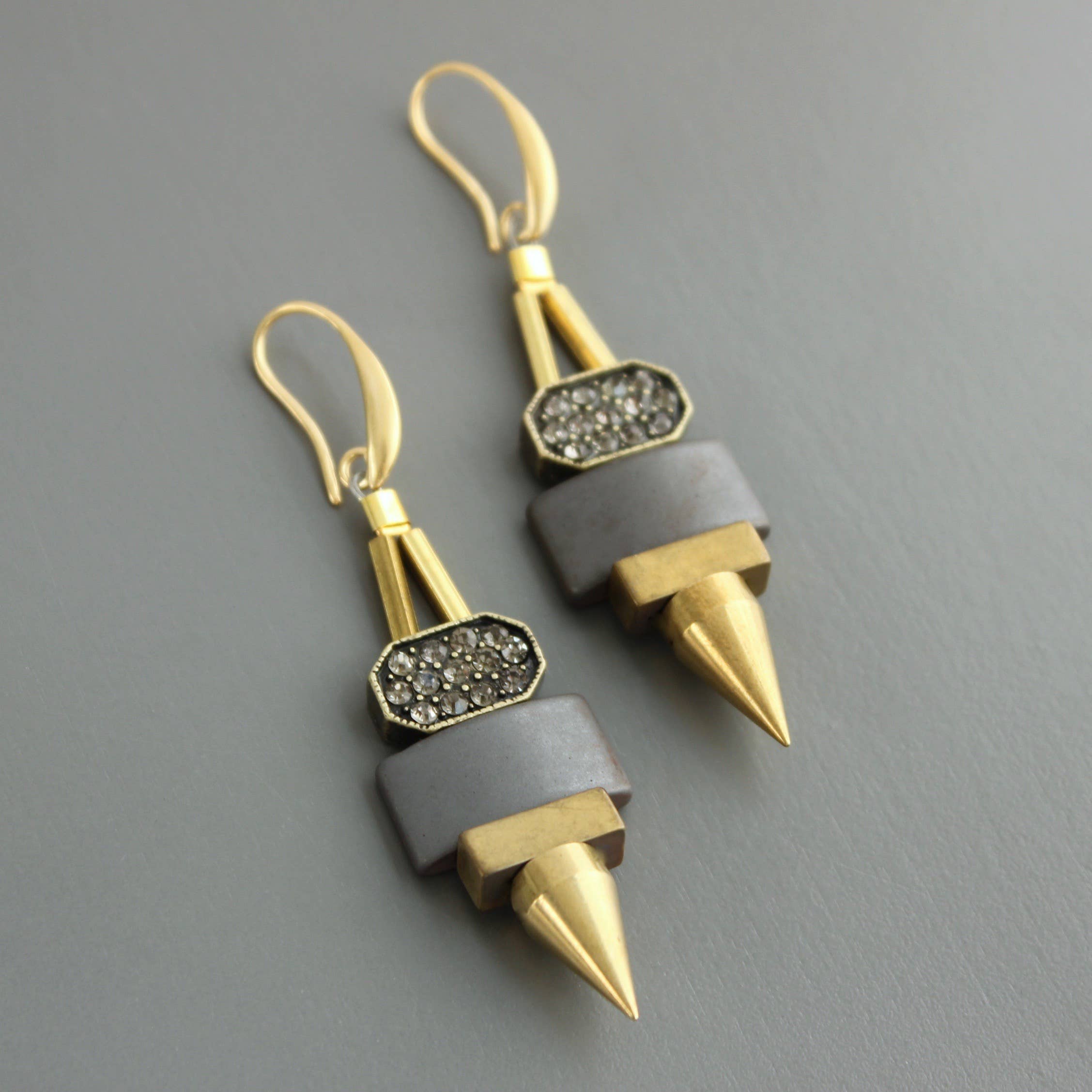 Pendientes colgantes con hematita natural, pedrería brillante y detalles en latón dorado. Diseño artesanal exclusivo de David Aubrey para Ivoluxt.