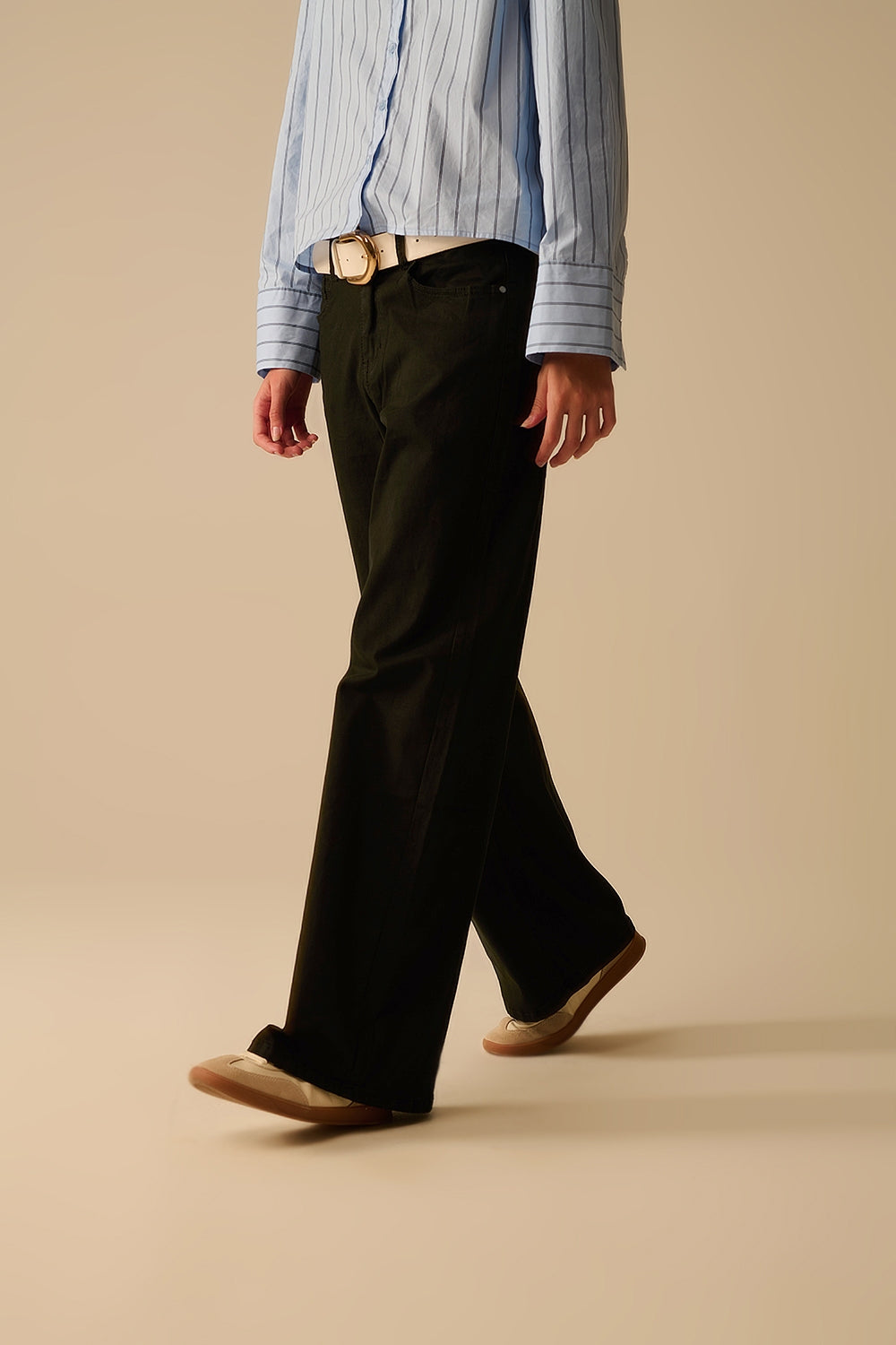 Vista de perfil de un pantalón negro de pierna recta mostrando la caída del tejido.