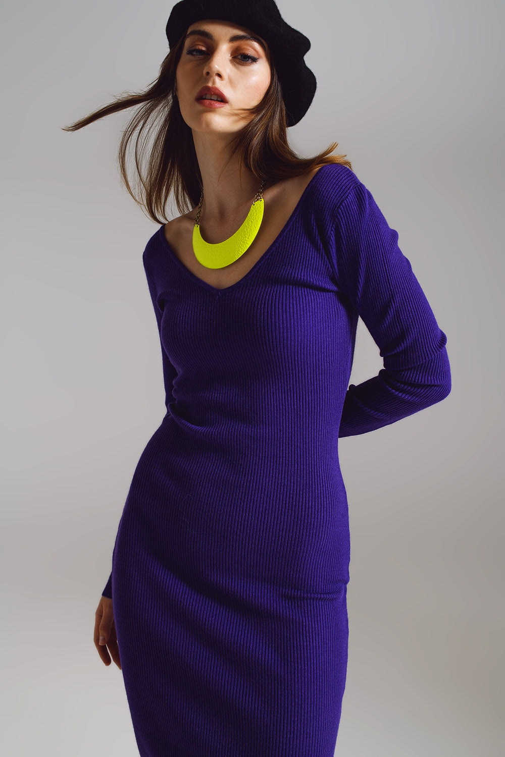 Vista de perfil de un vestido midi de punto de canalé en color morado.