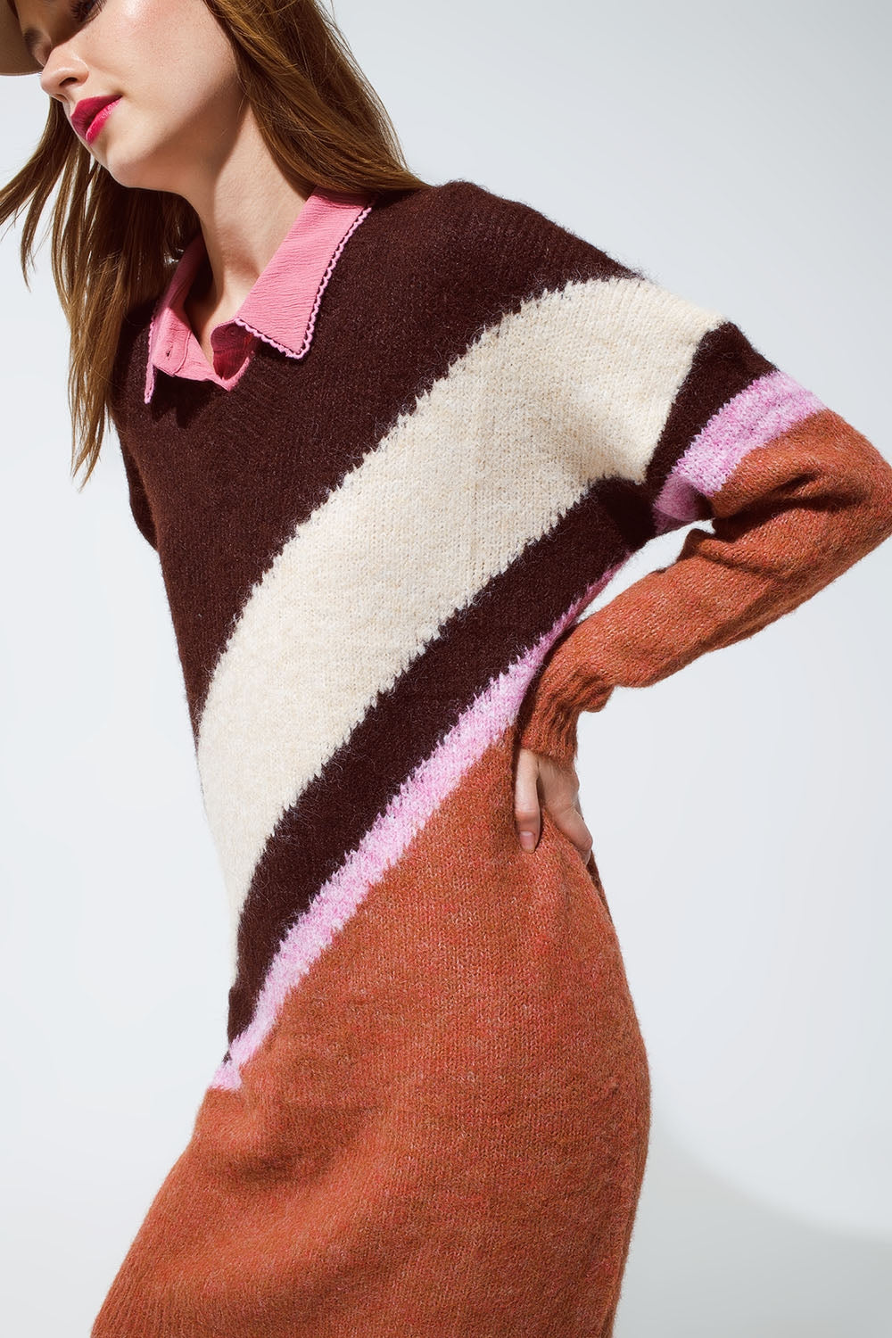 Plano medio de una modelo con vestido de punto oversize de inspiración años 70 y cuello de camisa rosa.