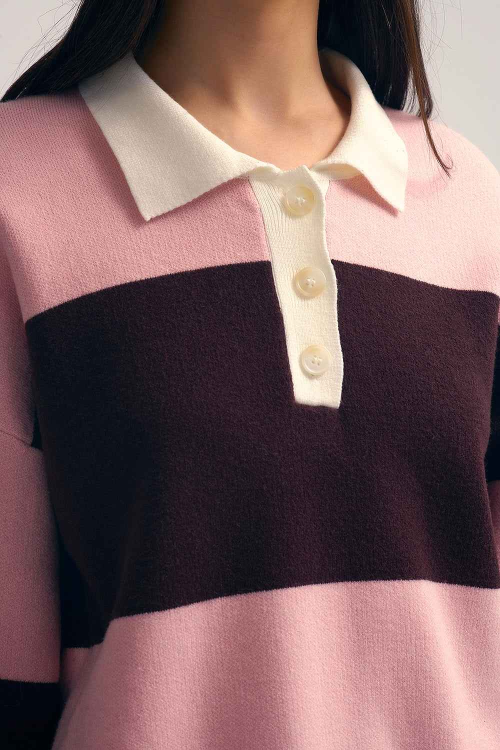Polo de punto rosa con rayas marrones detalle tejido