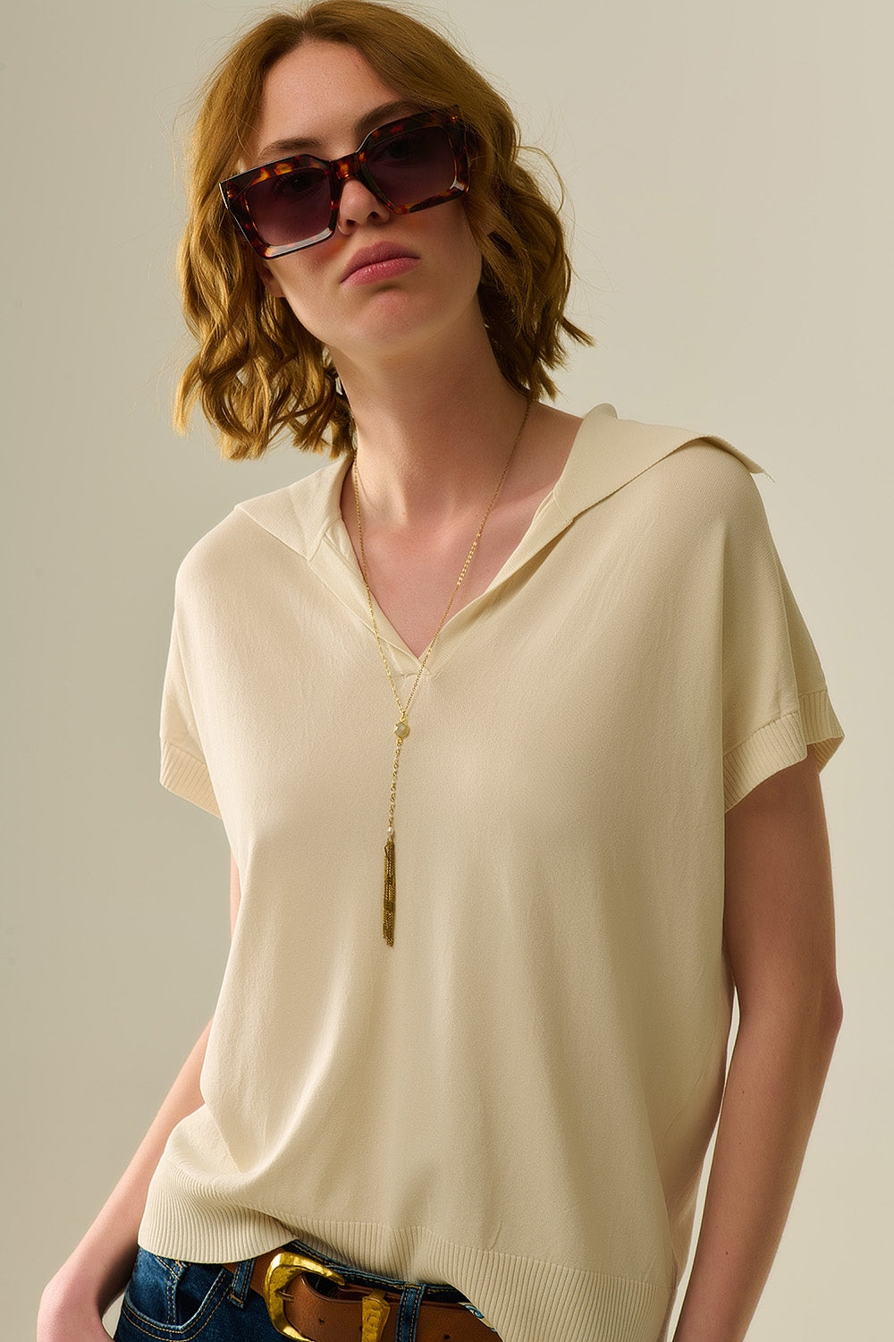 Polo de punto fino para mujer en color crema, con cuello en V sin botones y corte relajado 