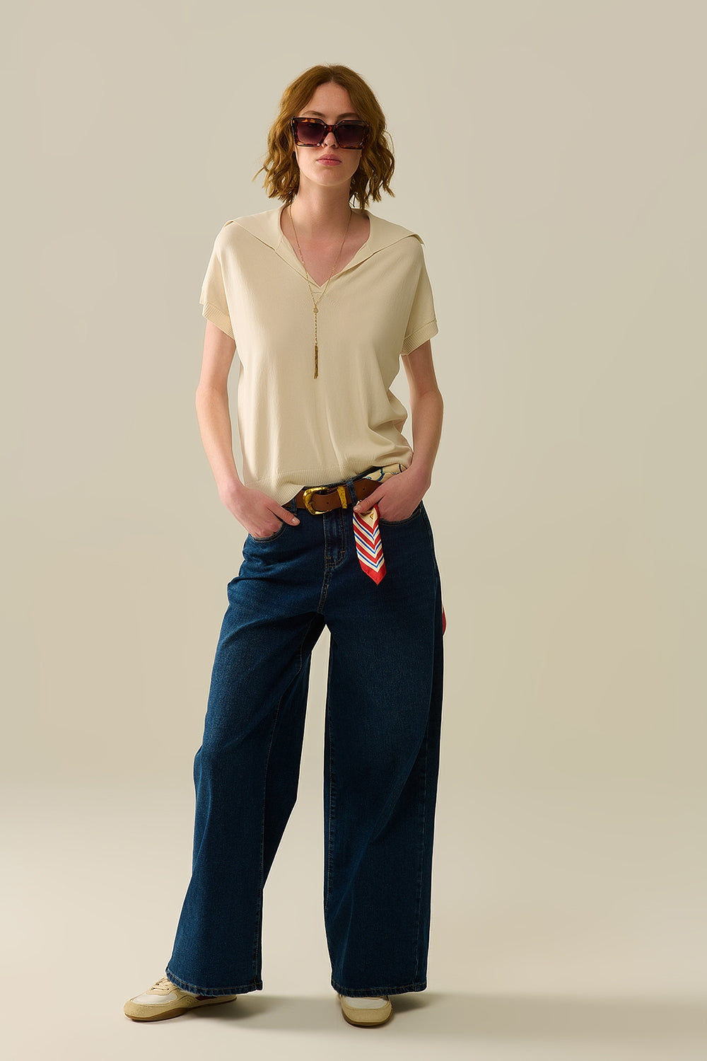 Polo de punto fino para mujer en color crema, cuello en V sin botones y corte relajado. Look completo.