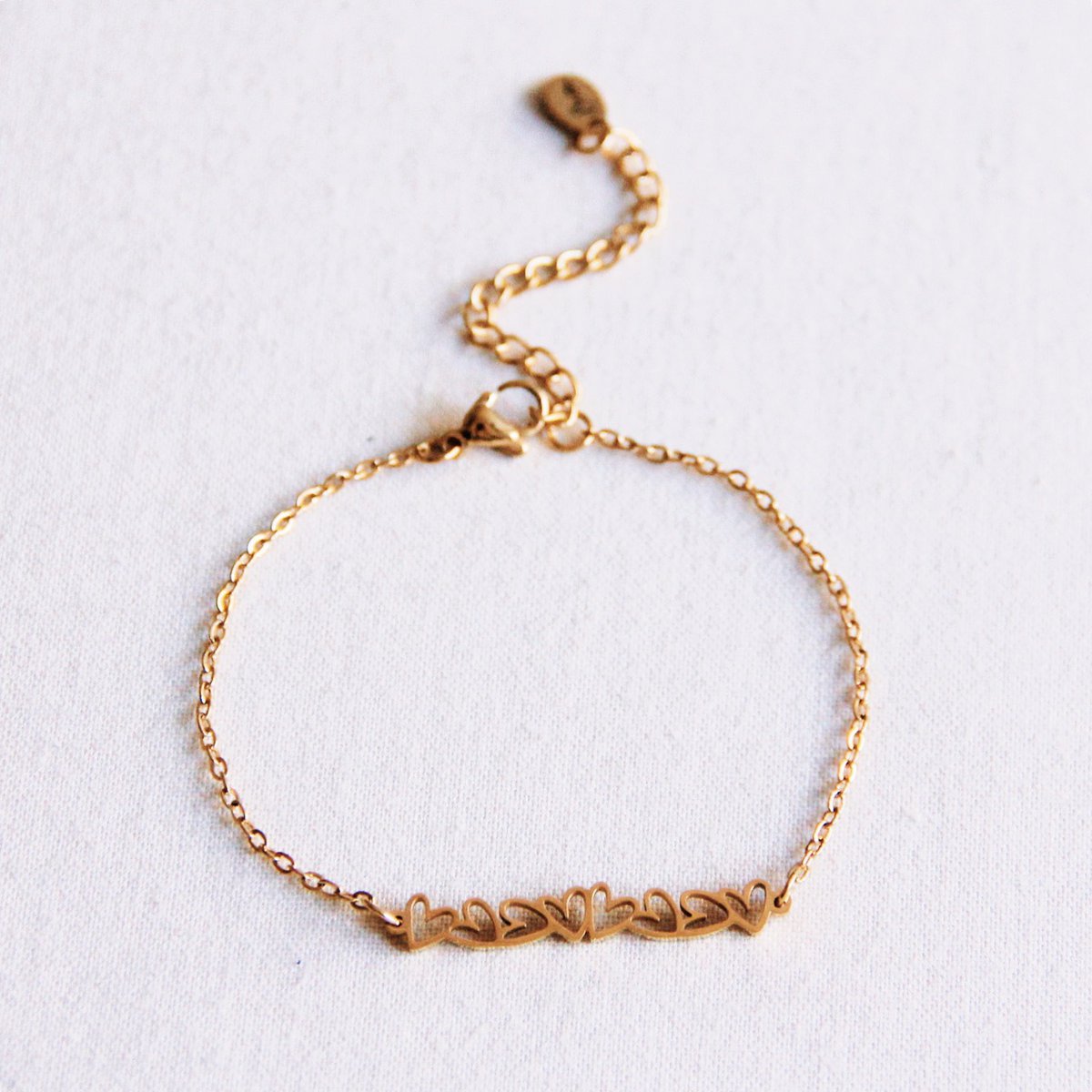 Pulsera de cadena fina con corazones y cierre ajustable de extensión.