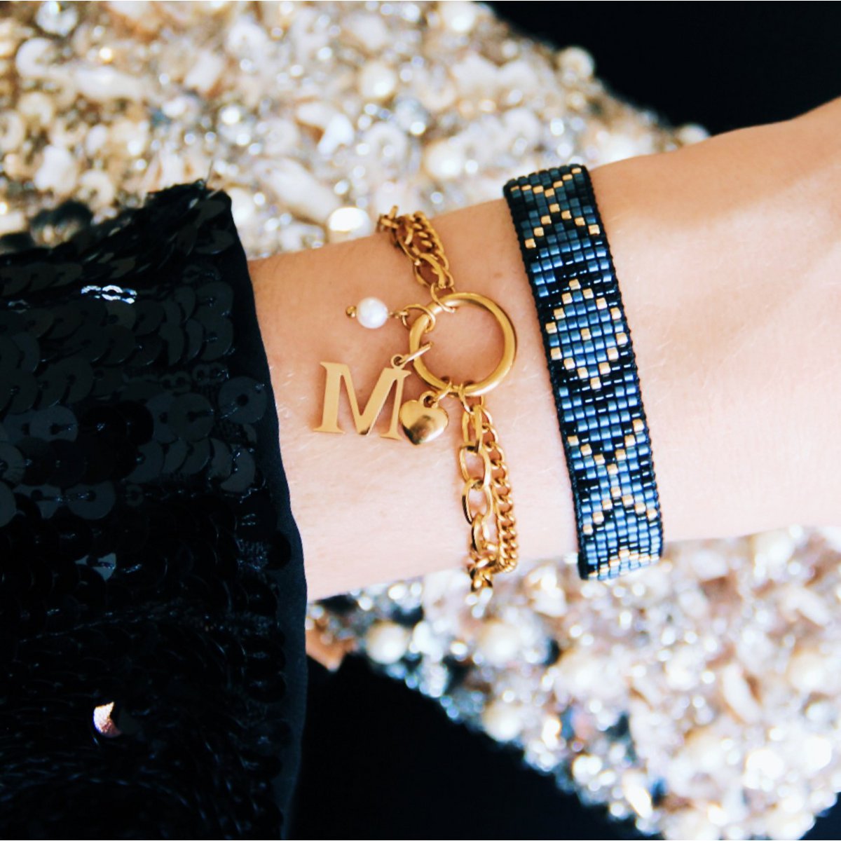 pulsera tejida de cuentas Miyuki negras y doradas combinada con pulsera de cadena de oro.