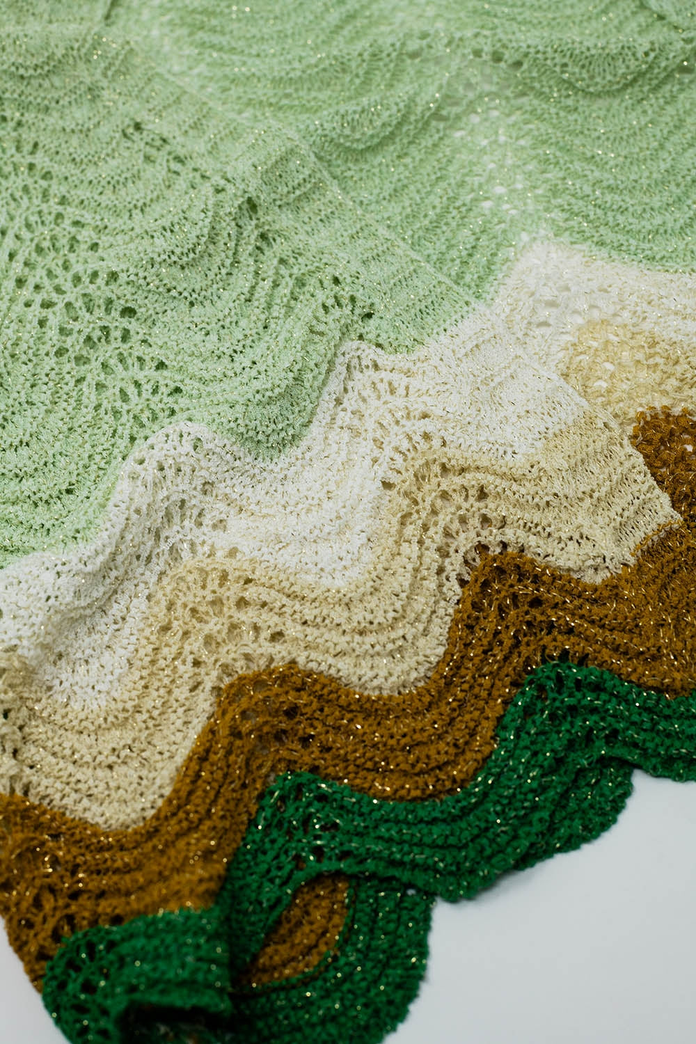 Rebeca corta de punto con mangas de ángel y detalle de ondas multicolor en verde