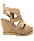 Sandalia de cuña alta de la marca Nemonic en piel de ante color taupe, con aberturas geométricas, ribete dorado y estrellas de metal.