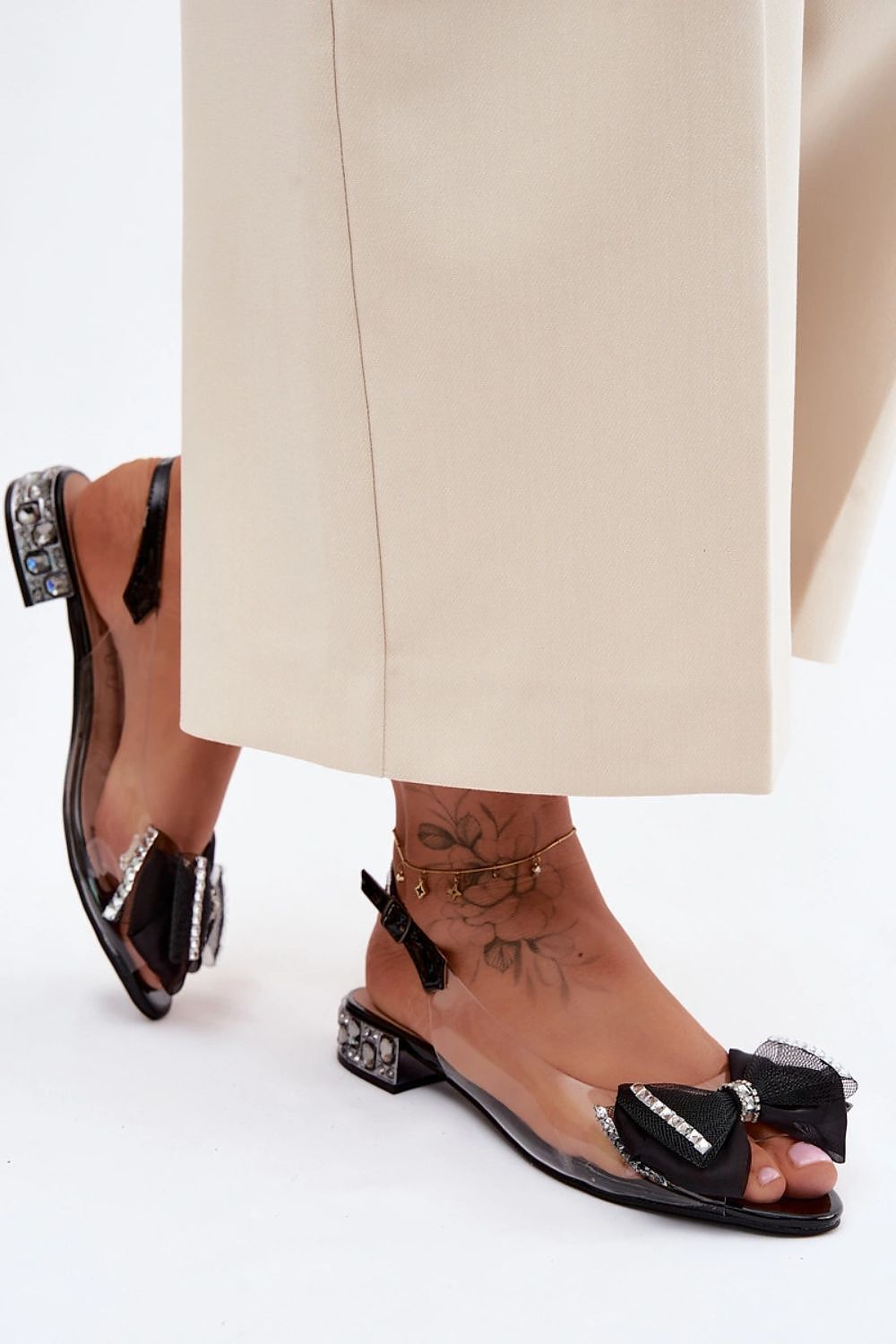 sandalias transparentes bajas con lazo negro de pedrería y tacón joya