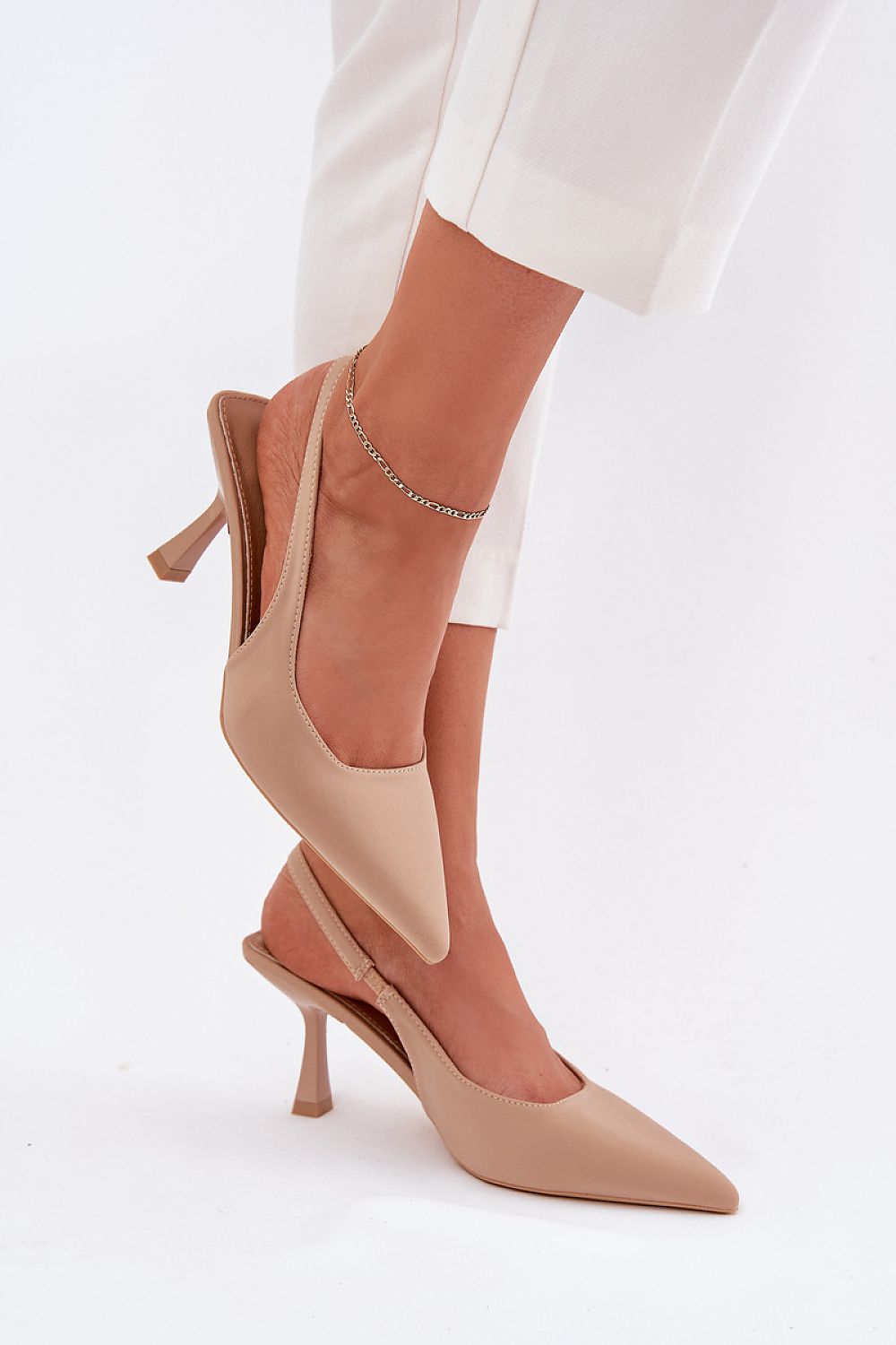 Sandalias nude con acabado suave y punta afilada, fondo blanco.