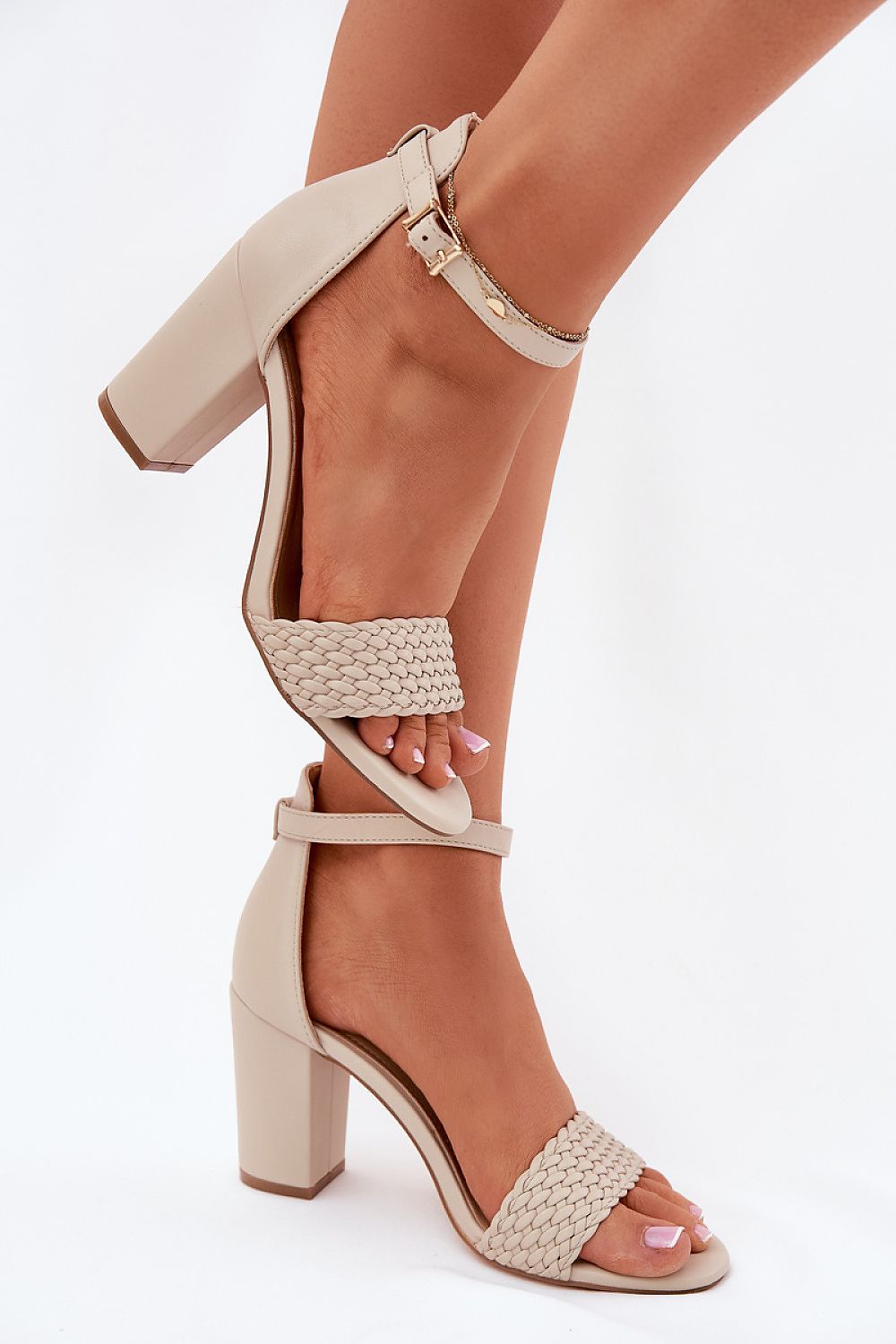 Primer plano de sandalias de tacón beige con detalle trenzado