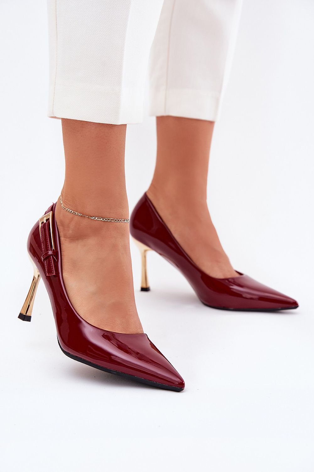Stilettos burdeos con hebilla dorada y tacón dorado