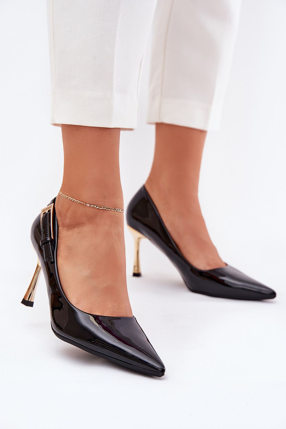 Stilettos negros de charol con tacón dorado y hebilla