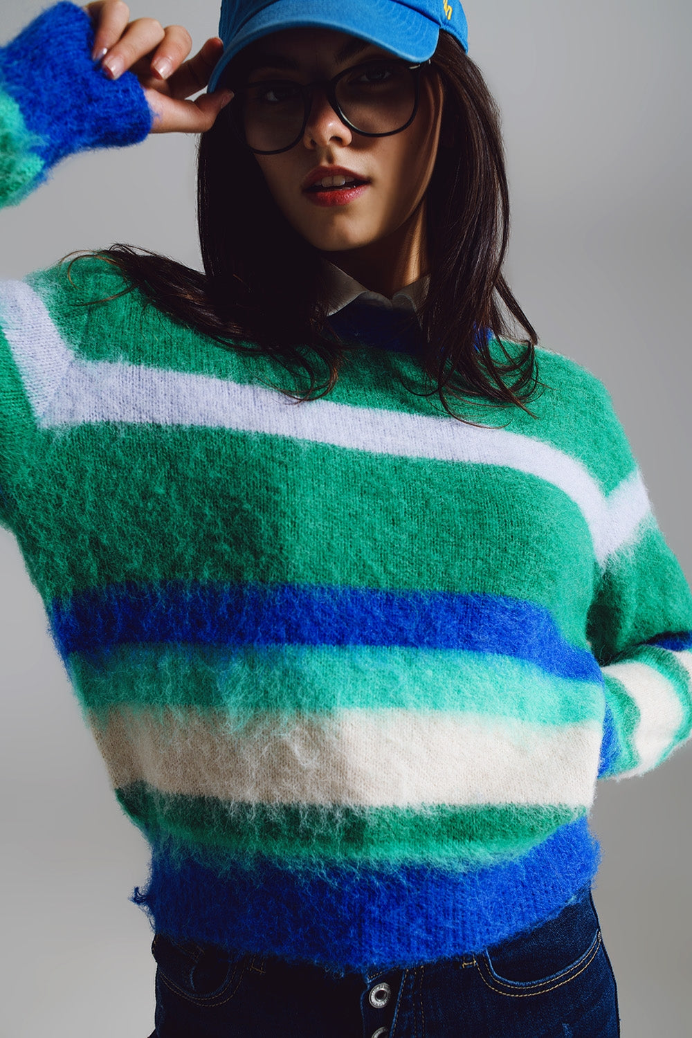Vista frontal de un jersey de punto suave y peludo con rayas anchas en azul, verde y blanco.
