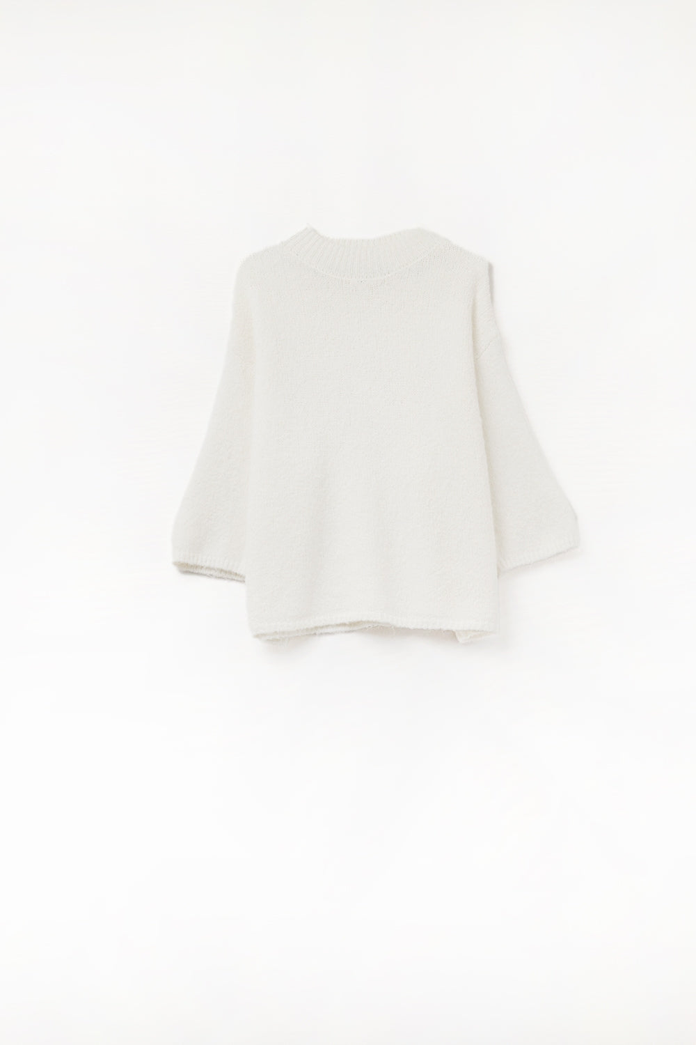 jersey de punto mullido en color crema, con manga tres cuartos y cuello redondo.