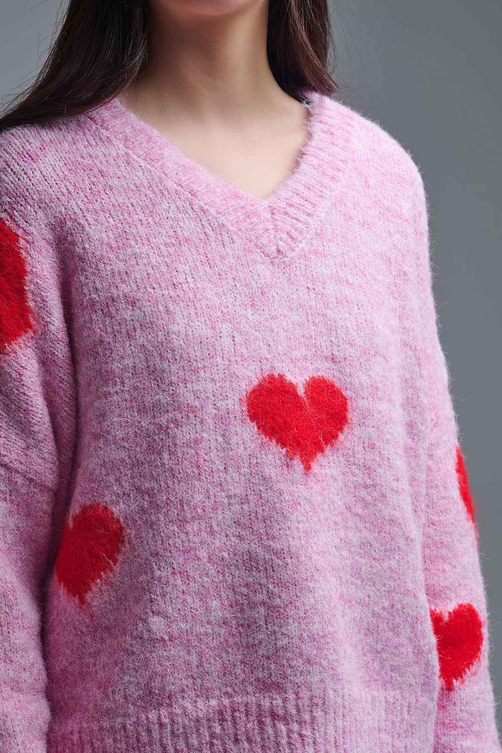Suéter rosa de manga larga con cuello en V y corazones rojos