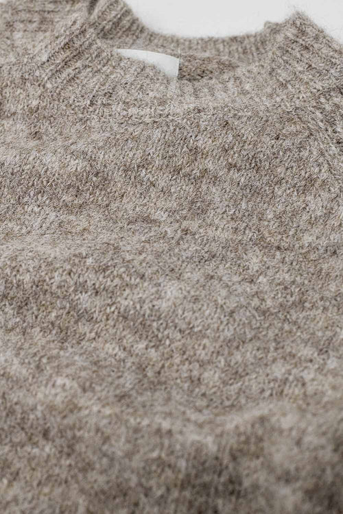 Primer plano de la textura del tejido de punto mezcla de lana en color beige avena de un suéter.