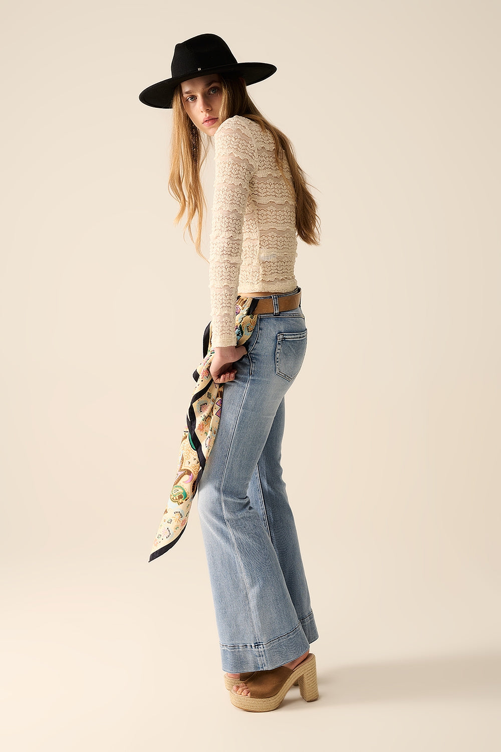 Top de encaje floral ajustado combinado con vaqueros y accesorios elegantes