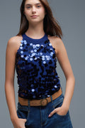 top halter de punto azul eléctrico con lentejuelas grandes y vaqueros.