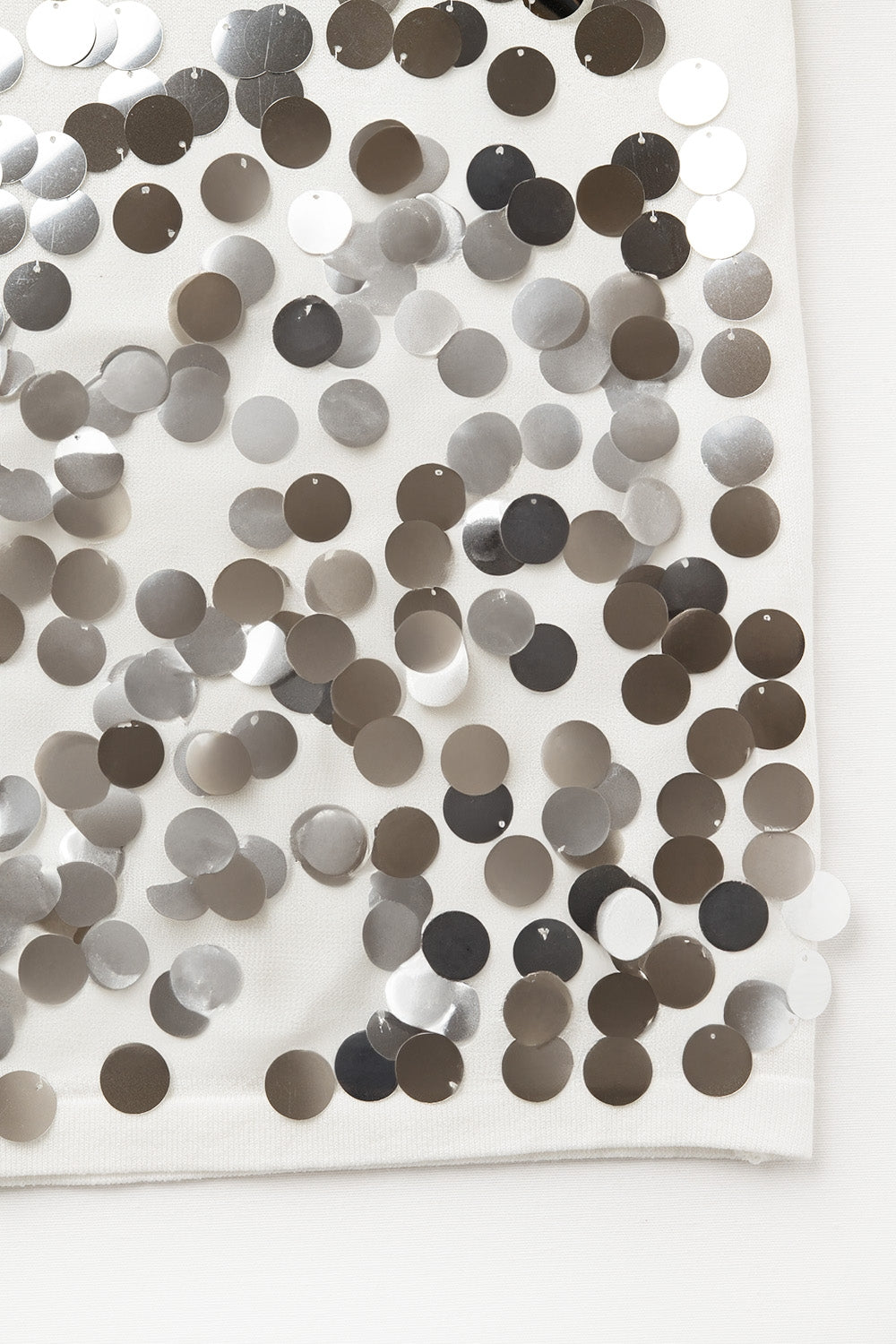 Top de punto blanco con detalle de lentejuelas