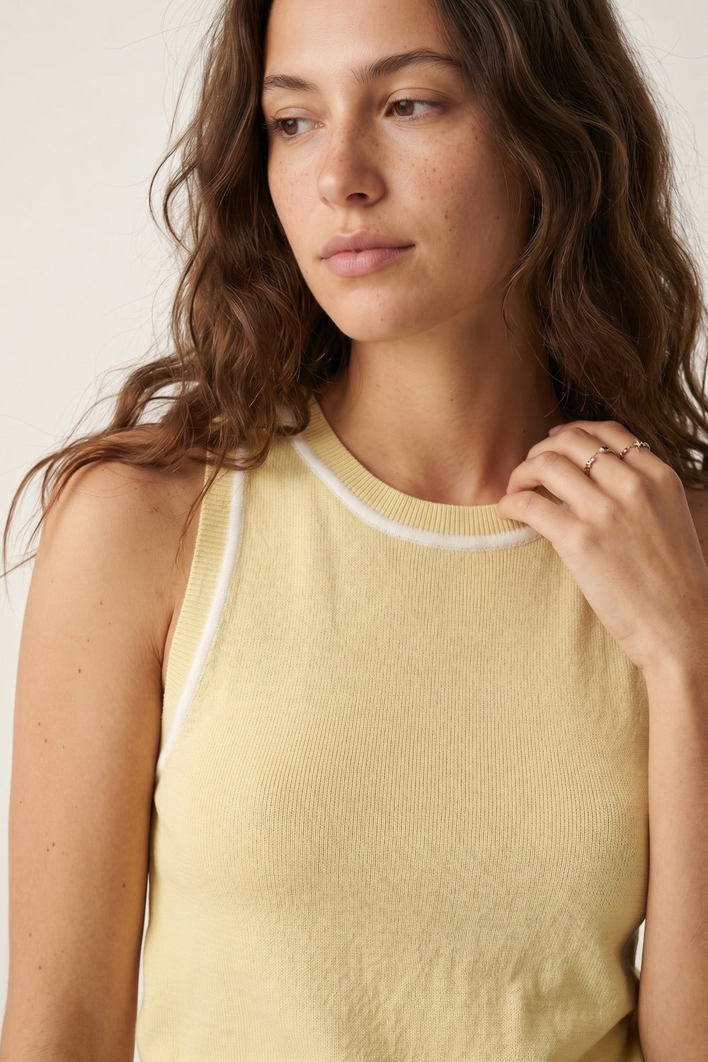 Top halter amarillo mantequilla de punto fino con ribetes blancos combinado con falda vaquera clara.
