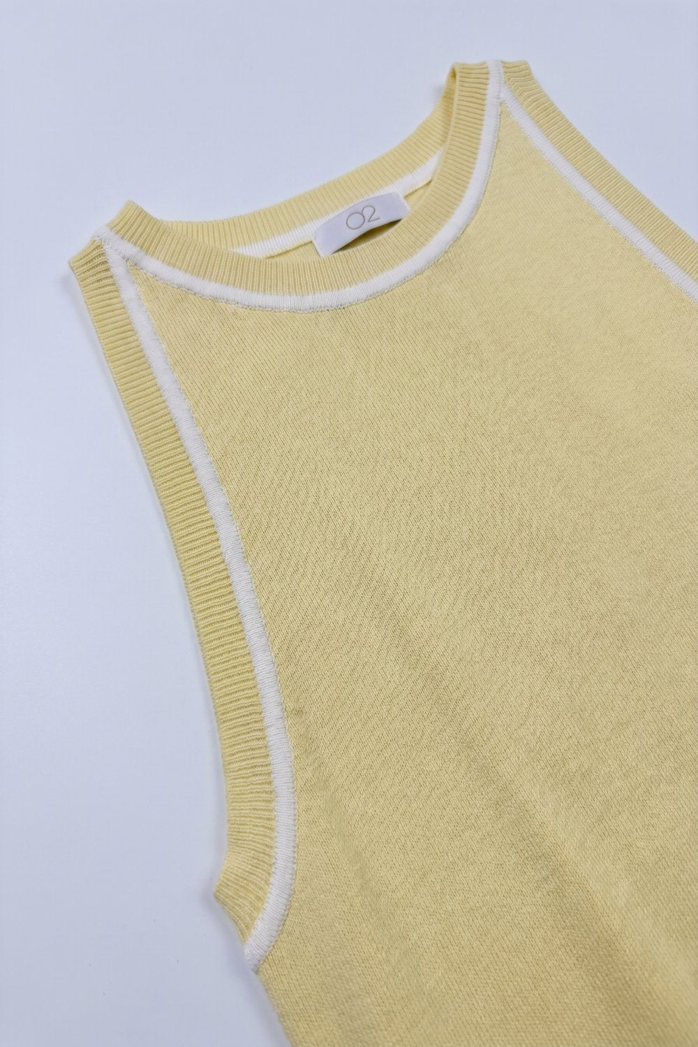Top halter amarillo mantequilla de punto fino con ribetes blancos.
