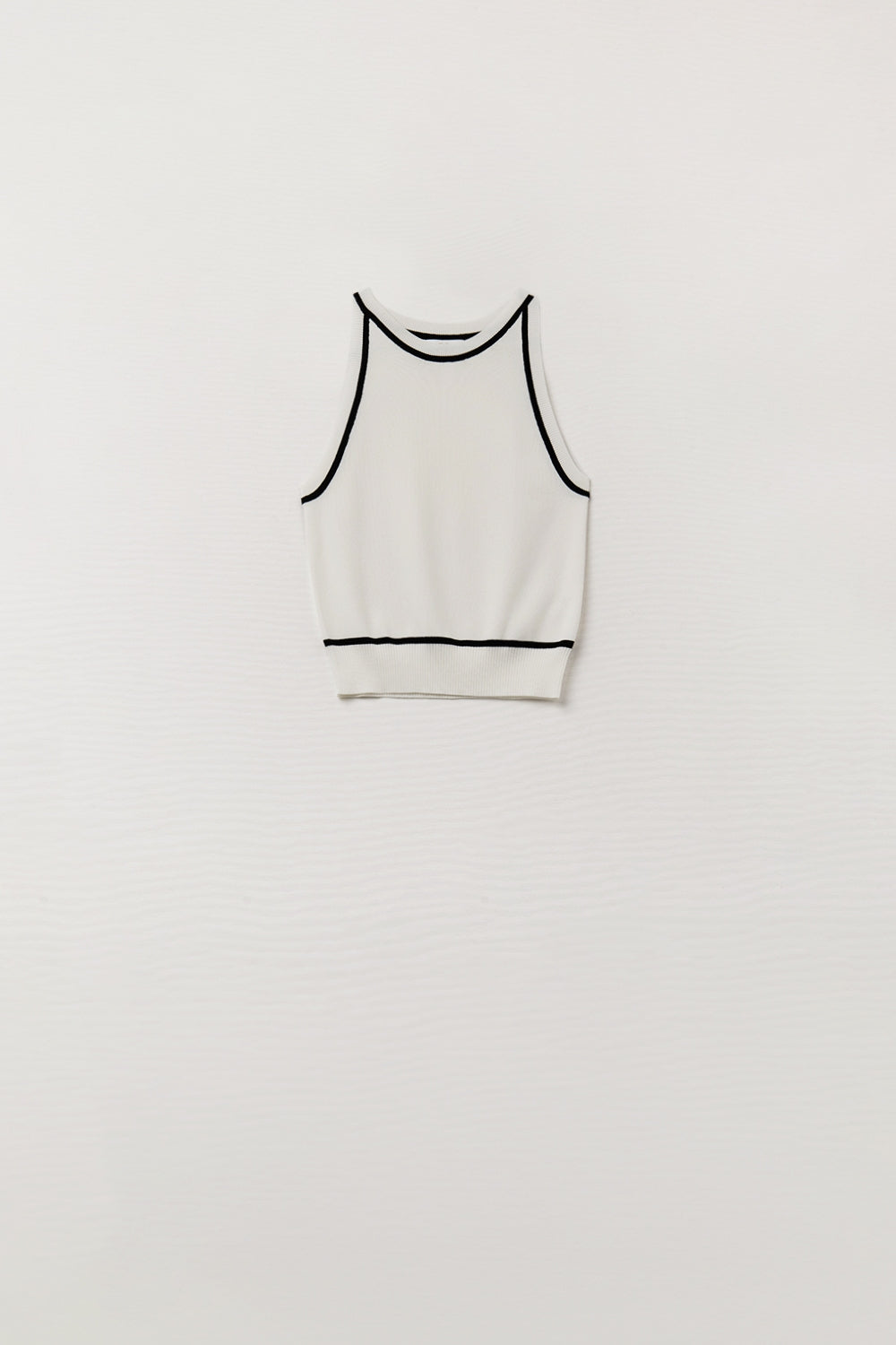 Top halter blanco de punto fino con detalles negros en contraste y corte ajustado.
