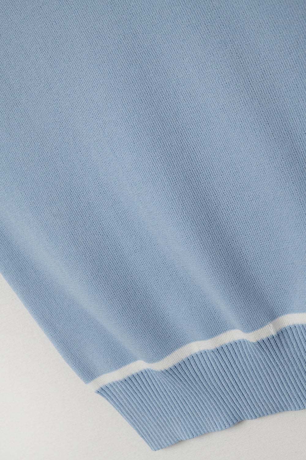 Top halter azul cielo de punto fino con ribetes blancos y corte ajustado para mujer.