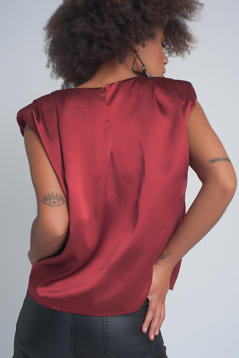 Top de satén en color rojo vino con hombreras marcadas y cuello redondo estilo sofisticado.