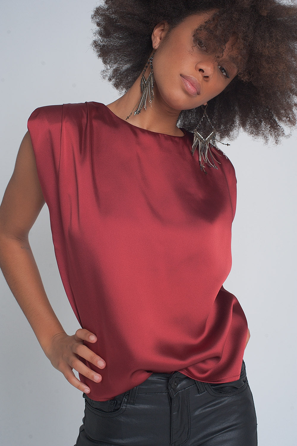 Top de satén en color rojo vino con hombreras marcadas y cuello redondo estilo sofisticado.