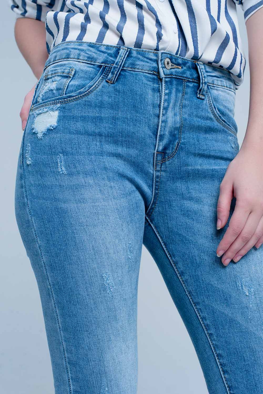 Vaqueros ajustados en azul con detalle rasgado