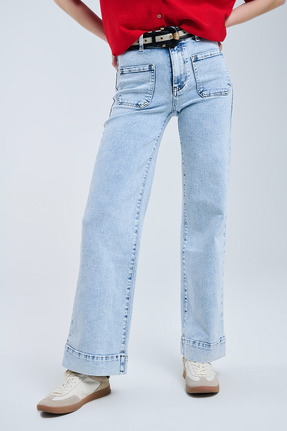 Modelo con vaquero de pernera ancha y talle alto en lavado azul claro.