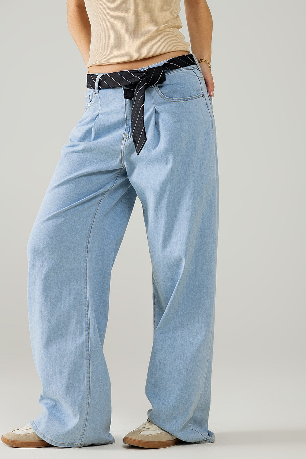 Modelo con vaquero baggy de pernera extra ancha en lavado claro, con talle alto de pinzas