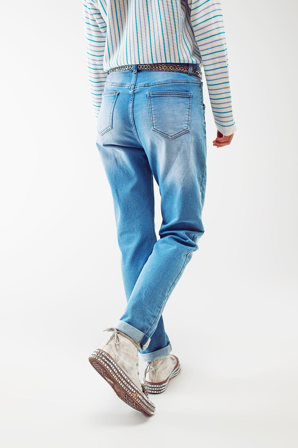 Vaqueros de mujer corte boyfriend en azul claro con cierre de botones exteriores, diseño de cinco bolsillos y efecto desgastado.