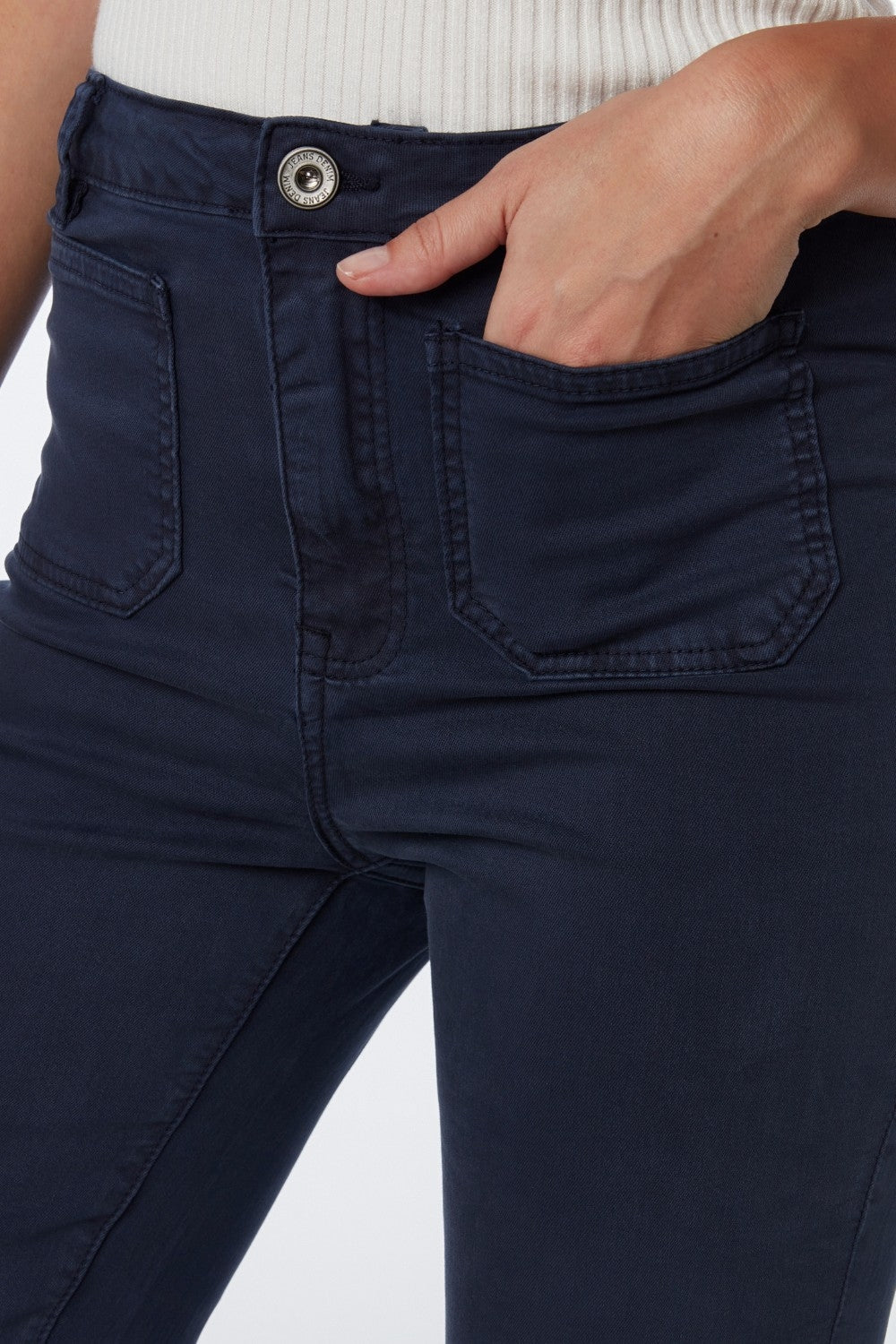 Primer plano del bolsillo de parche y el tejido de un pantalón de algodón en color azul marino.
