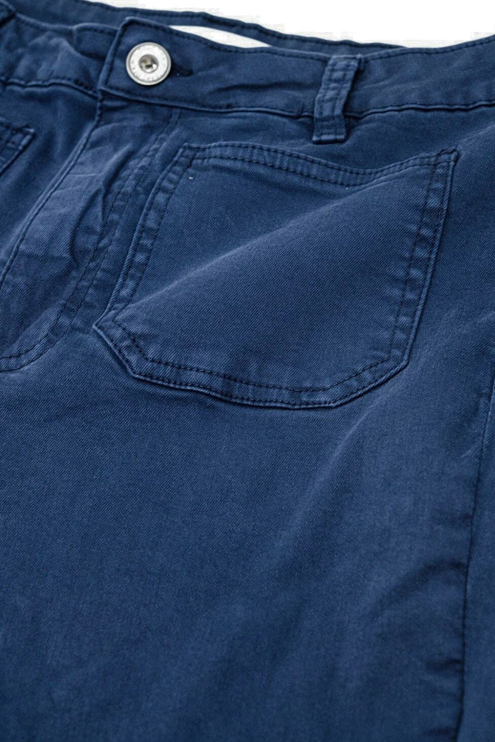 Primer plano del bolsillo de parche y el tejido de un pantalón de algodón en color azul marino.