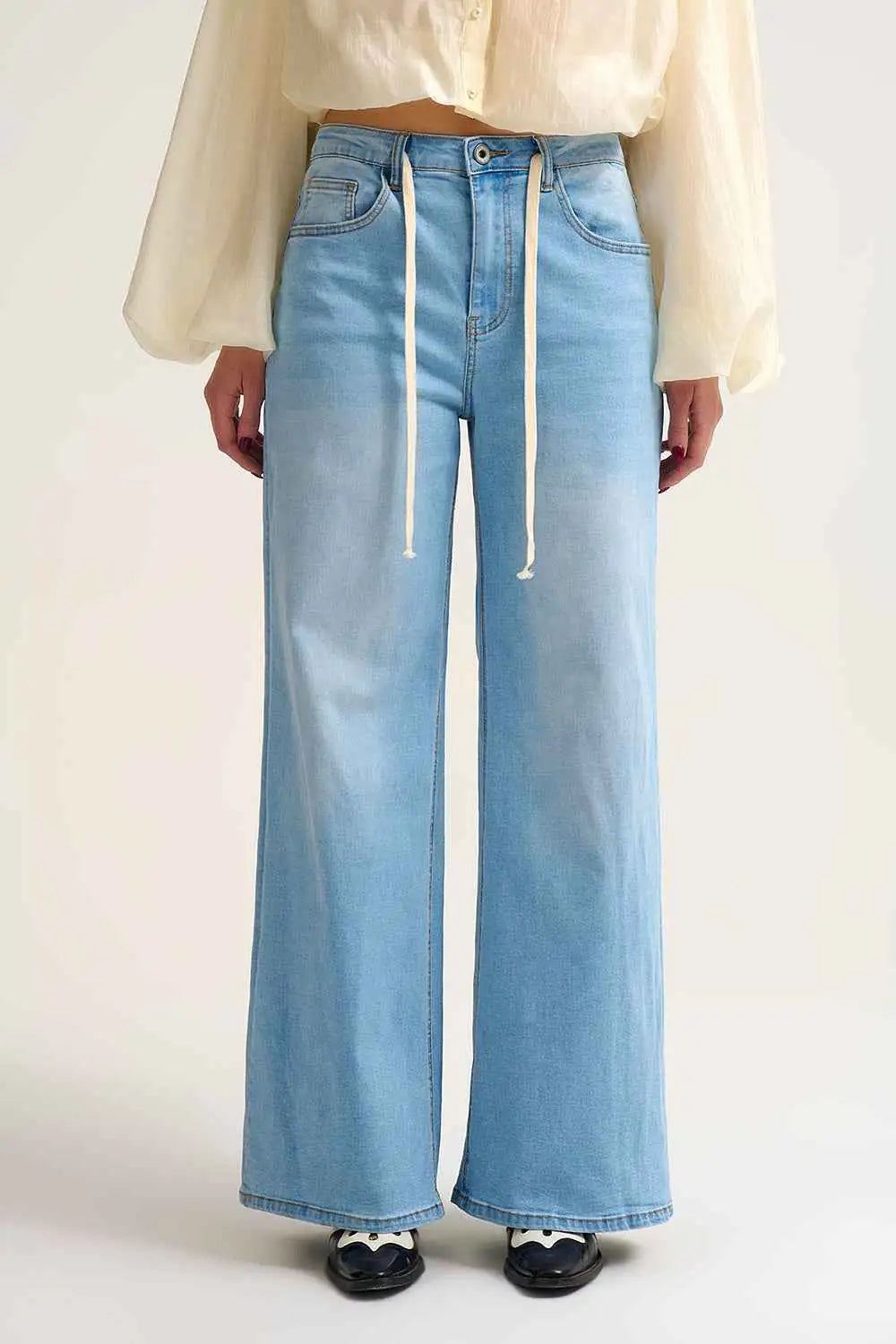Vaqueros de pierna ancha para mujer en color azul claro con detalle de cordón ajustable en la cintura, estilo casual.