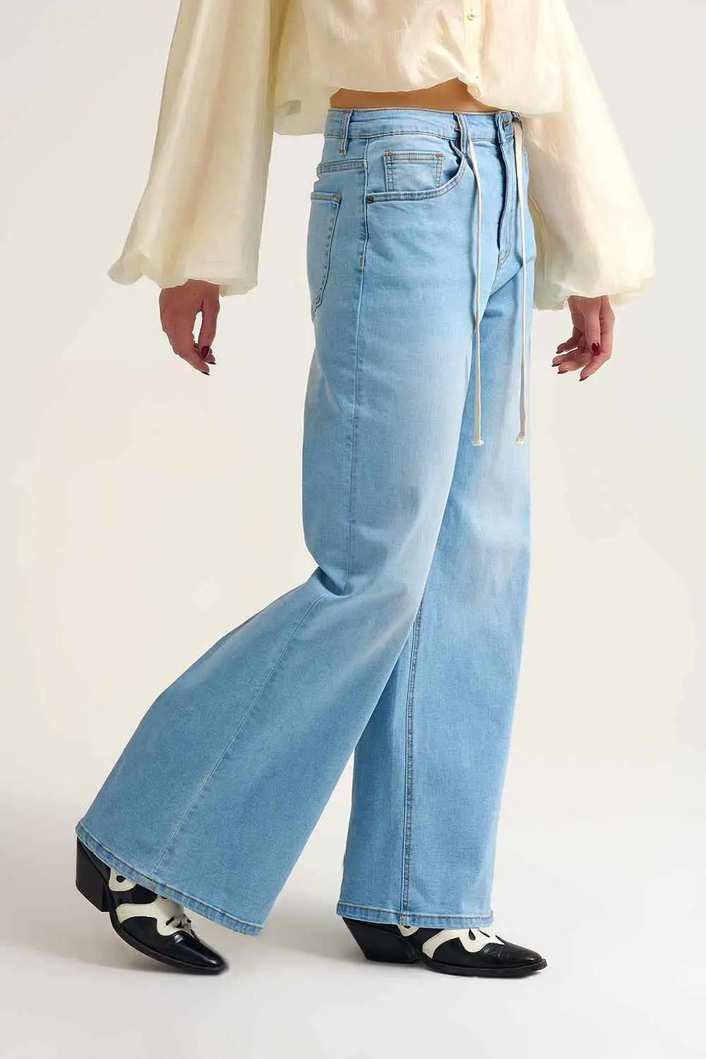 Vaqueros de pierna ancha para mujer en color azul claro con detalle de cordón ajustable en la cintura, estilo casual.