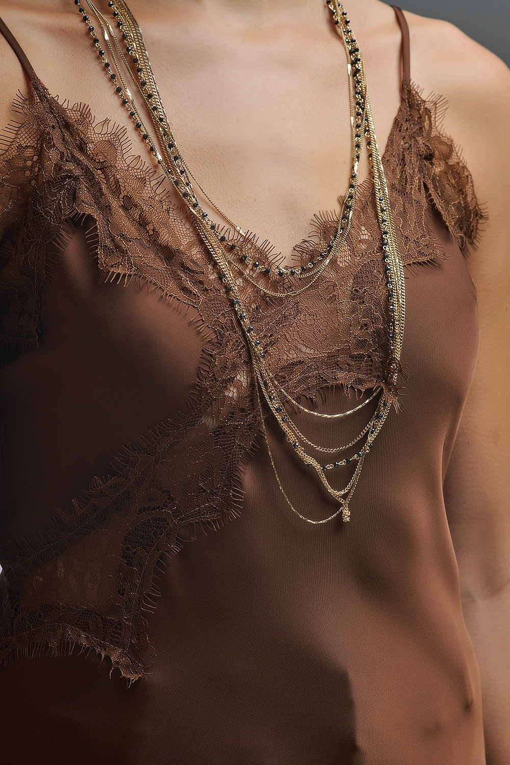 Detalle encaje en parte superior del vestido satinado en color marrón