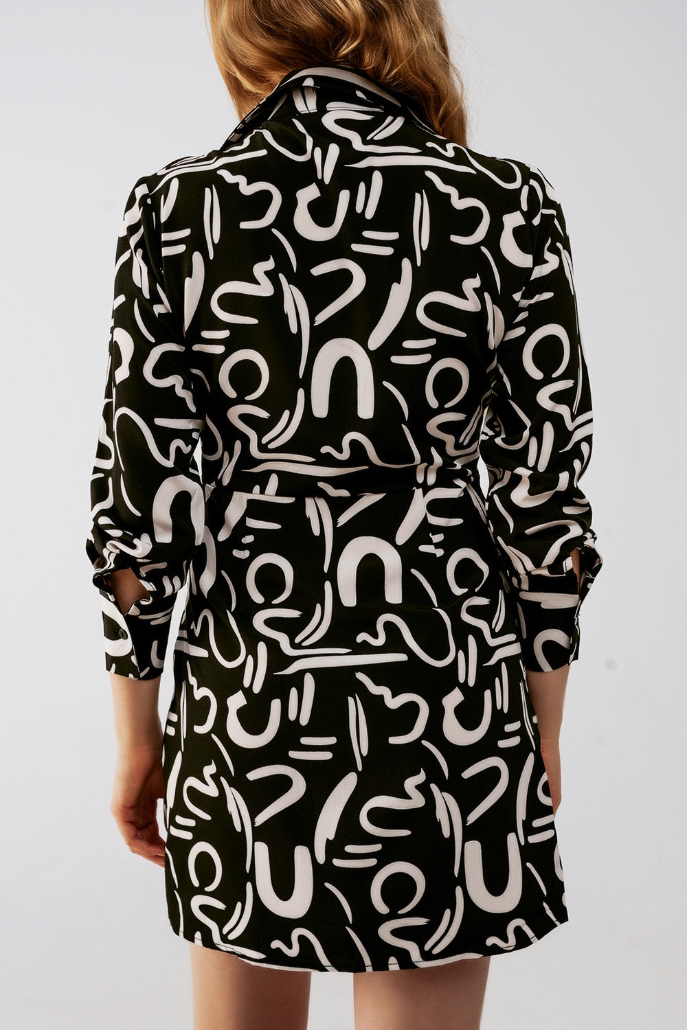Vista trasera de un vestido camisero corto con estampado gráfico.
