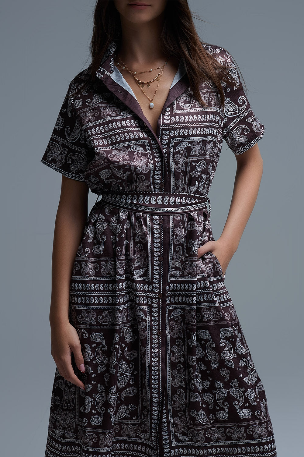 Detalle del cuello polo y escote del vestido paisley marrón.