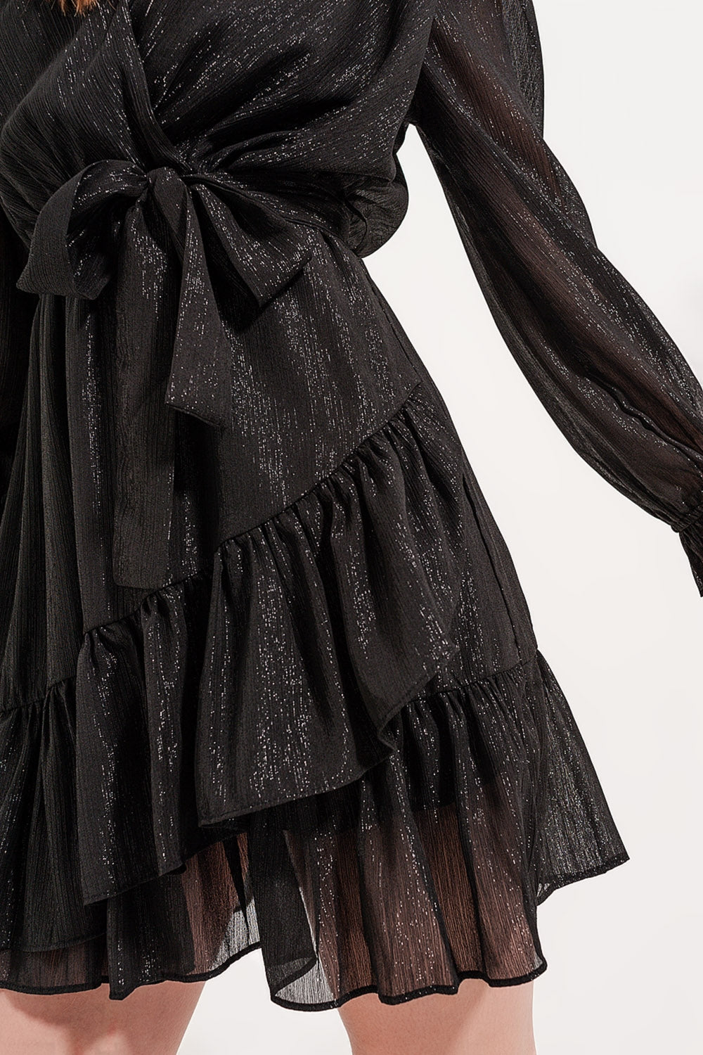 Detalle tejido de un vestido negro cruzado mostrando la textura del tejido con hilo metalizado.