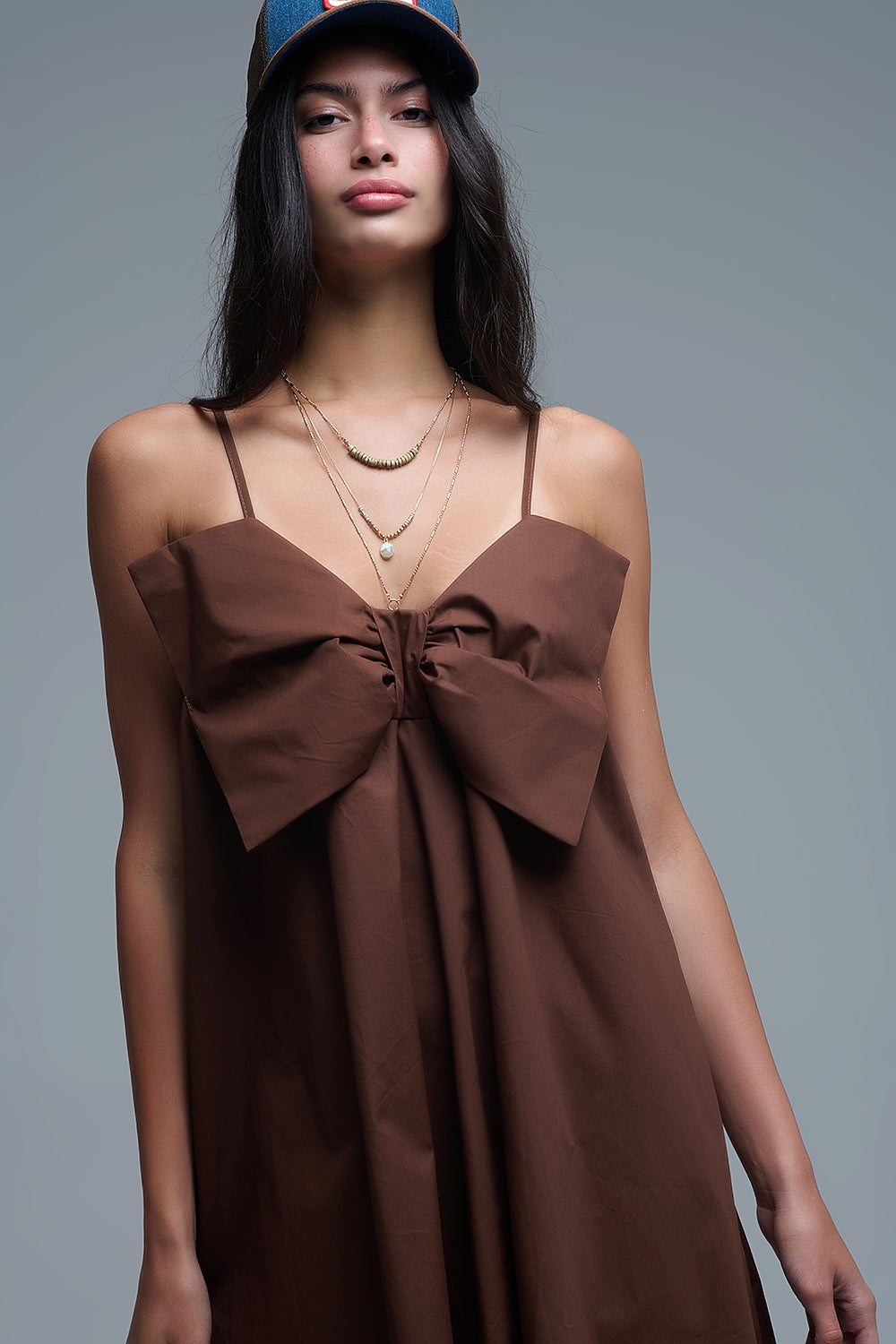 Detalle del lazo frontal del vestido y los collares en capas.