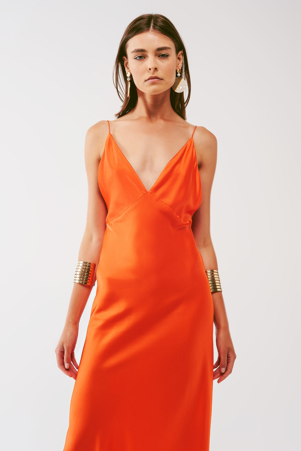 Primer plano del escote en V del vestido naranja satinado